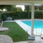 Standing on covered patio just outside back door overlooking inground pool. 4050 Adams St