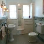 Spacious bathroom with pedestal sink and built-in cabinetry. Very charming!