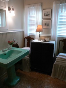 Very nice hall bathroom with original 1930's-era pedestal sink and toilet. There is also a tub and shower to the right.