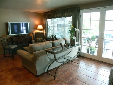 Spacious family room with top-of-the-line porcelain floor tiles and French doors overlooking the large covered patio.