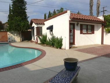 View of permitted guest quarters with bathroom overlooking refreshing pool.