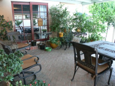 Alternate view of covered brick patio, with French sliders to master bedroom suite.