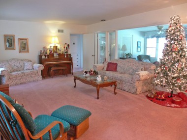 Front entrance view of spacious living room.  Hardwood floors under carpet.