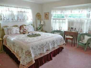 Spacious master bedroom with bay window and privacy shutters.