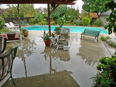 Rainy day photo looking out to backyard from family room. The plants/trees on far side of pool are hiding the fence that separates this yard from the secondary backyard!